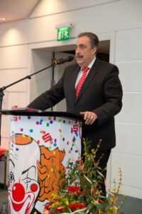Mann im schwarzen Anzug an Rednerpult
